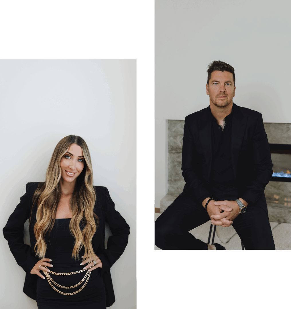 A woman with long hair in a black outfit and a man in a black suit sitting on a bench.